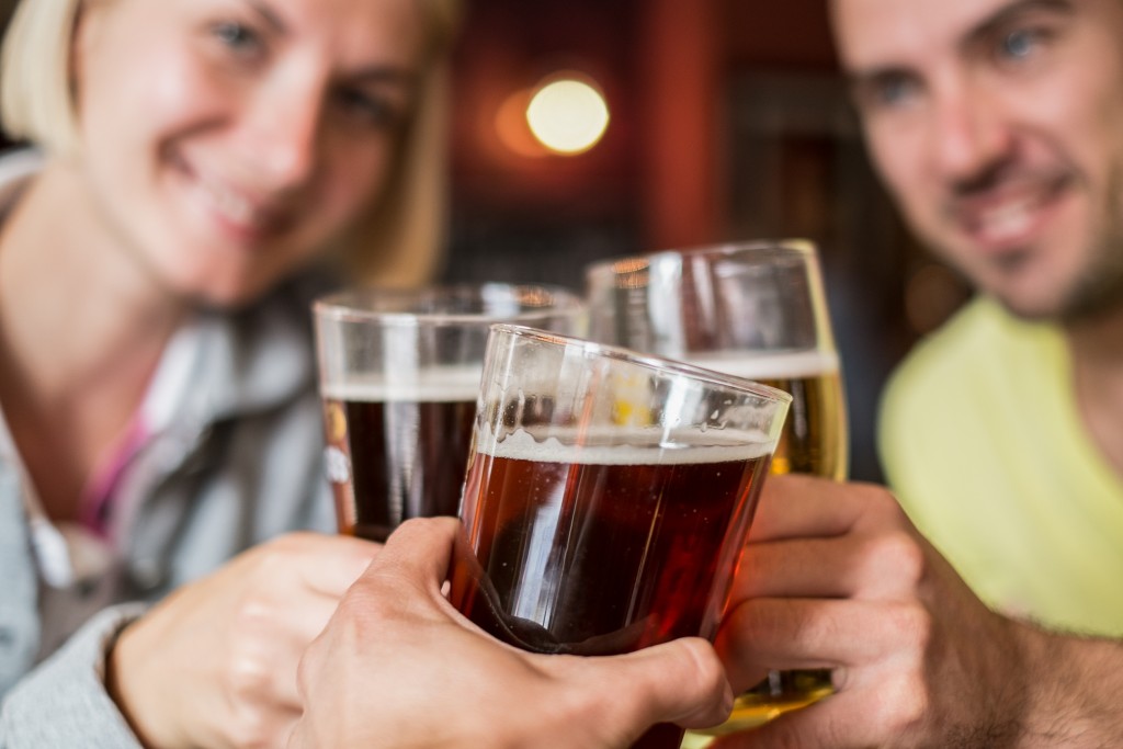 Friends with beer toasting in a pub